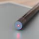 The tail end of the A5 stylus emitting a red laser beam.